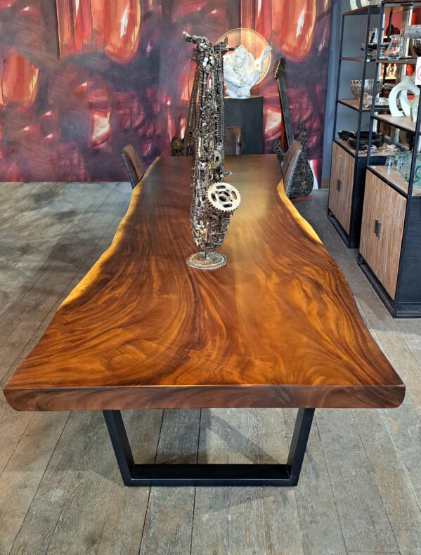 Organic Suar wood dining table seating 12, featuring a black steel base.