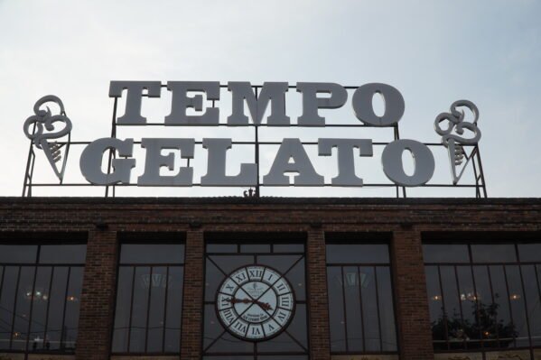 A large vintage industrial clock featuring a rustic design with bold numerals and exposed gears. The clock combines a weathered frame with metal accents, giving it a distinctive industrial look that adds character to any room. A large vintage industrial clock made of wood and metal, featuring a rustic design with bold numerals and exposed gears. The clock combines a weathered wooden frame with metal accents, giving it a distinctive industrial look that adds character to any room.