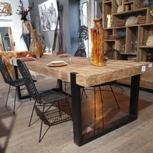 A rustic table made from recycled wood, featuring modern iron feet for a stylish and sturdy design.